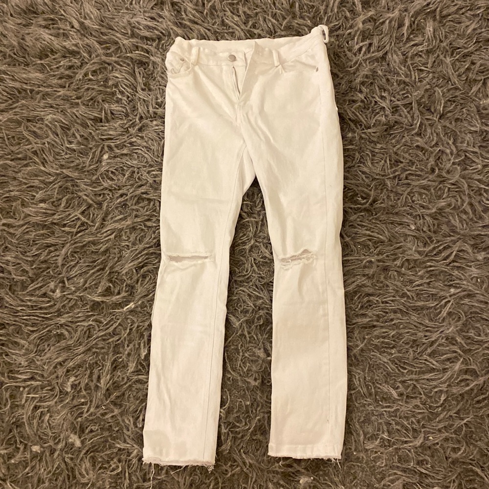 white jeans with rips at the knee